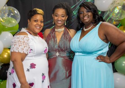 Kenyatta Calloway and two girls are shown wearing elegant gowns at the GEMS celebration.