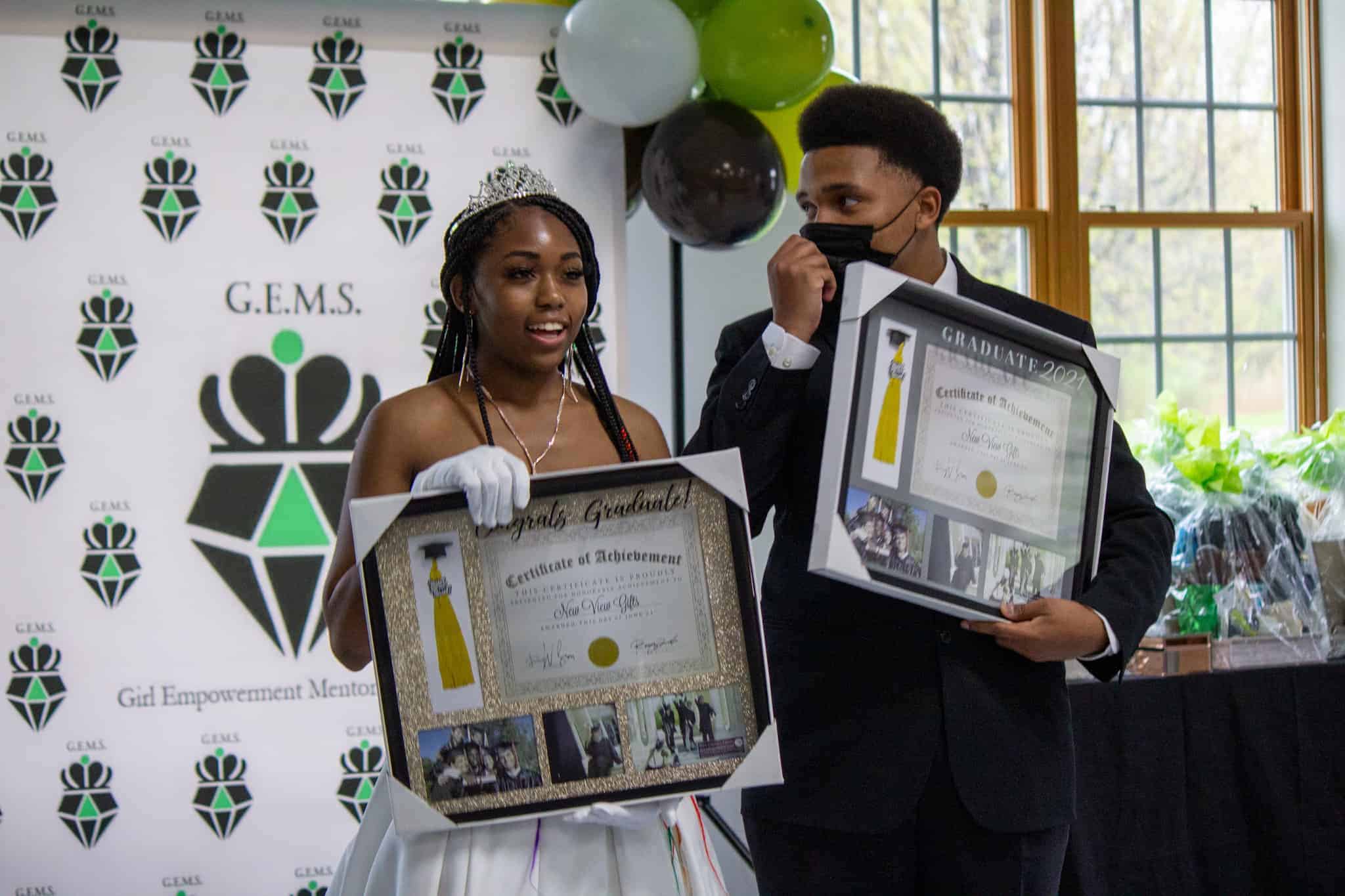 Two young people dressed very elegantly receive awards from their participation in the GEMS program.
