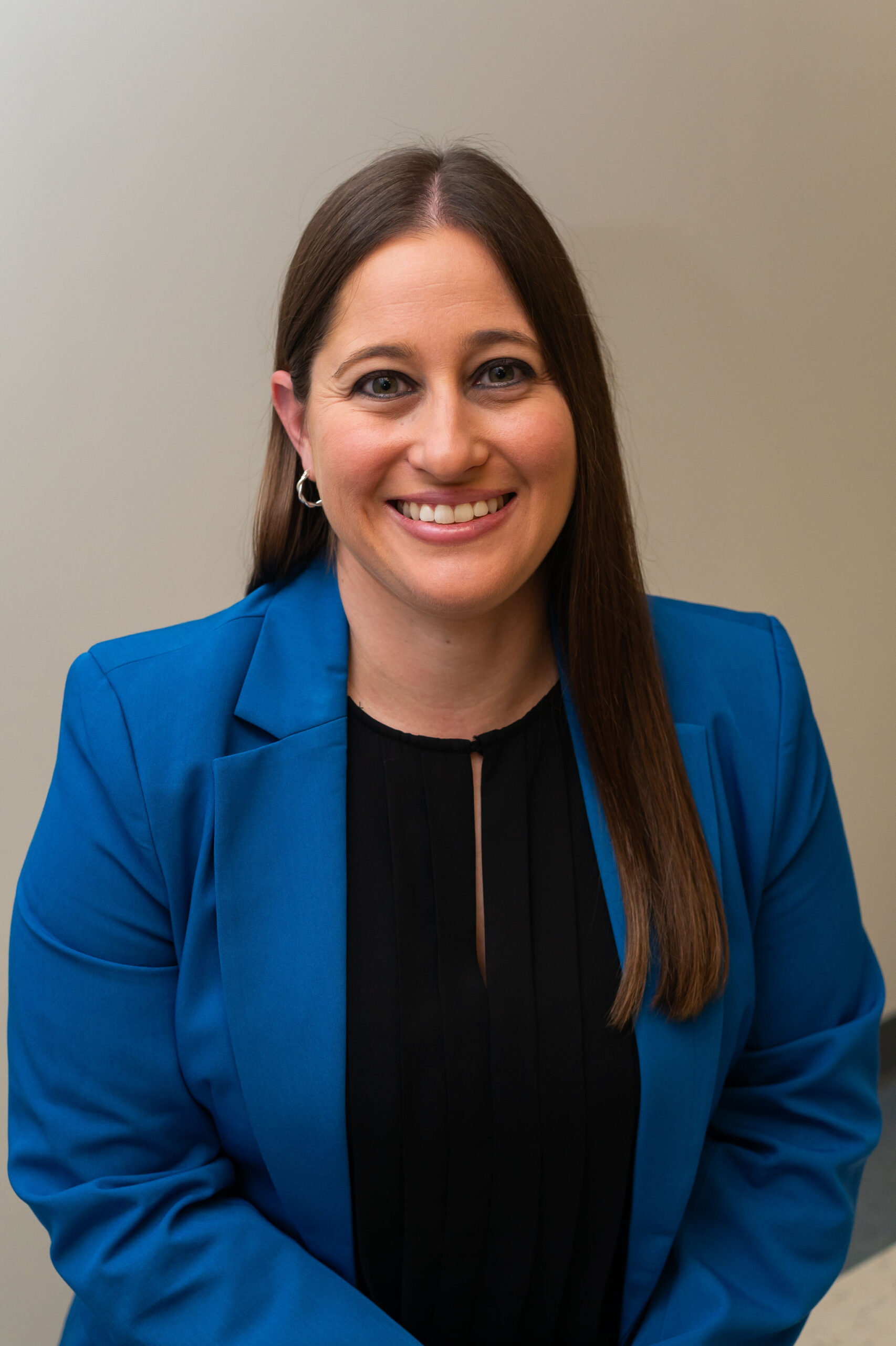 Shelby Baskin professional headshot in black shirt and blue blazer