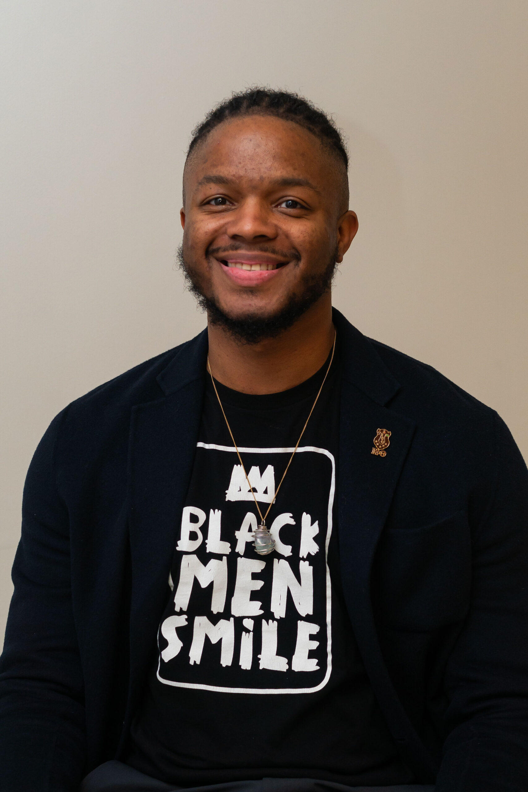 Terrian Garvis professional headshot with black shirt that says Black Men Smile