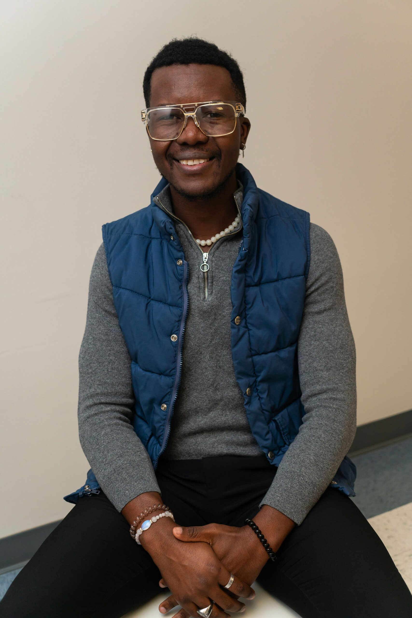 Thierry Kamanda professional headshot with gray long sleeved shirt and a blue puffer vest