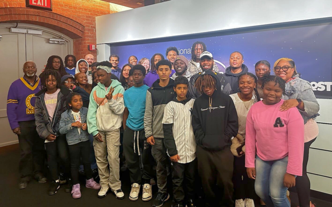 A large group of mostly African American youth and some adults who are members of Syracuse STEM NSBE posing for a group picture at The Most.