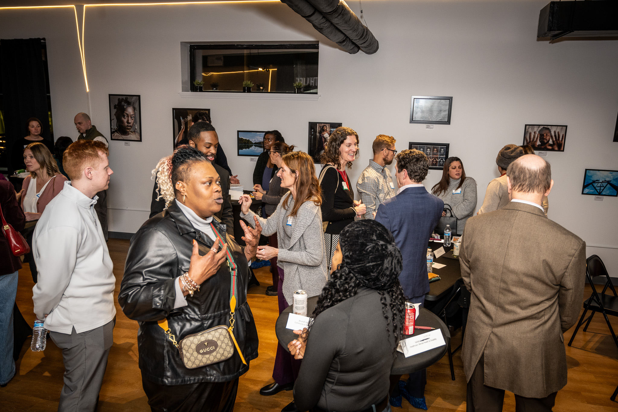 People networking at tables at an art gallery venue.