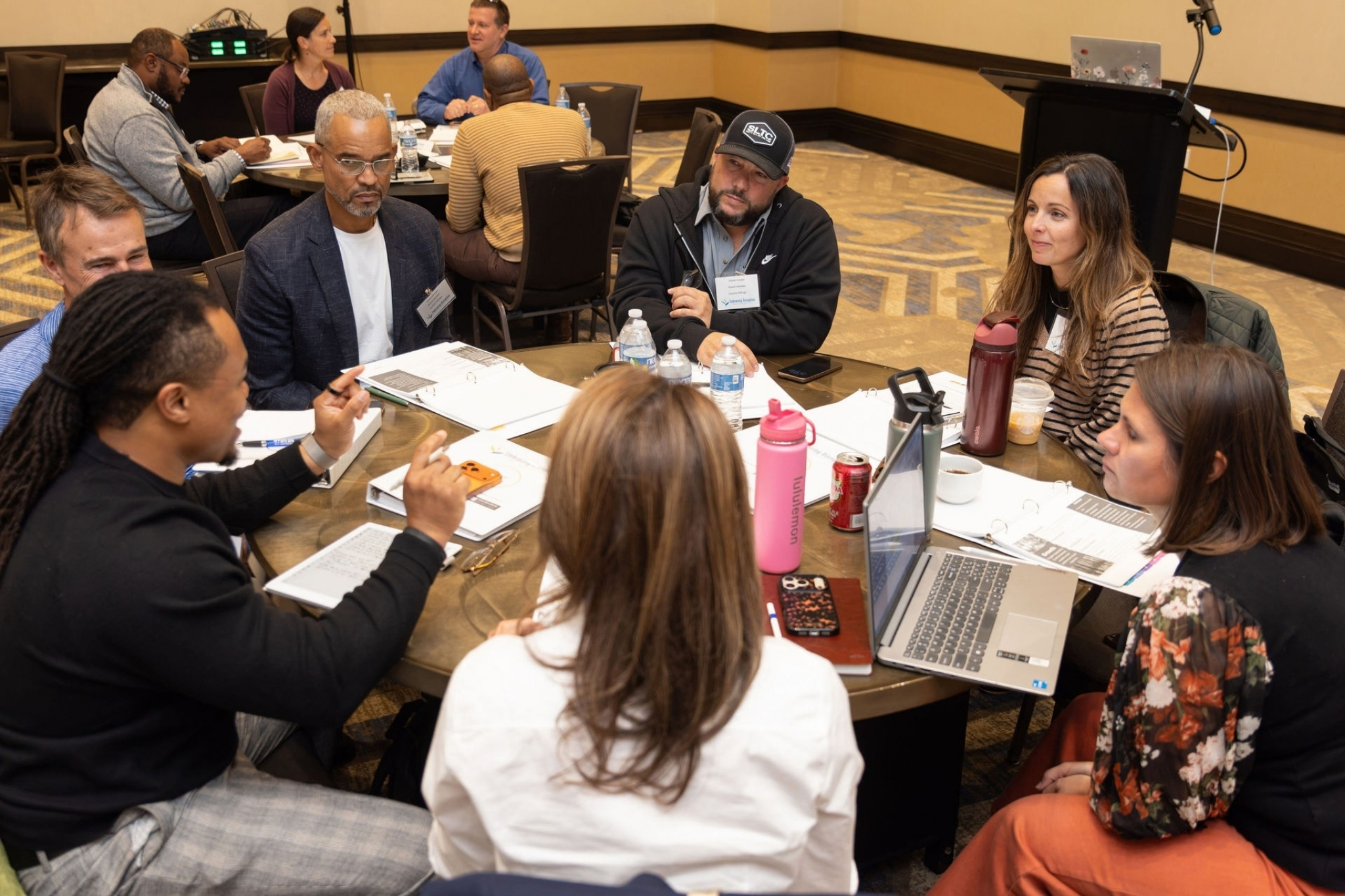 Group of professionals sitting at a round table having a discussion at Gifford's Embracing Disruption program kick off